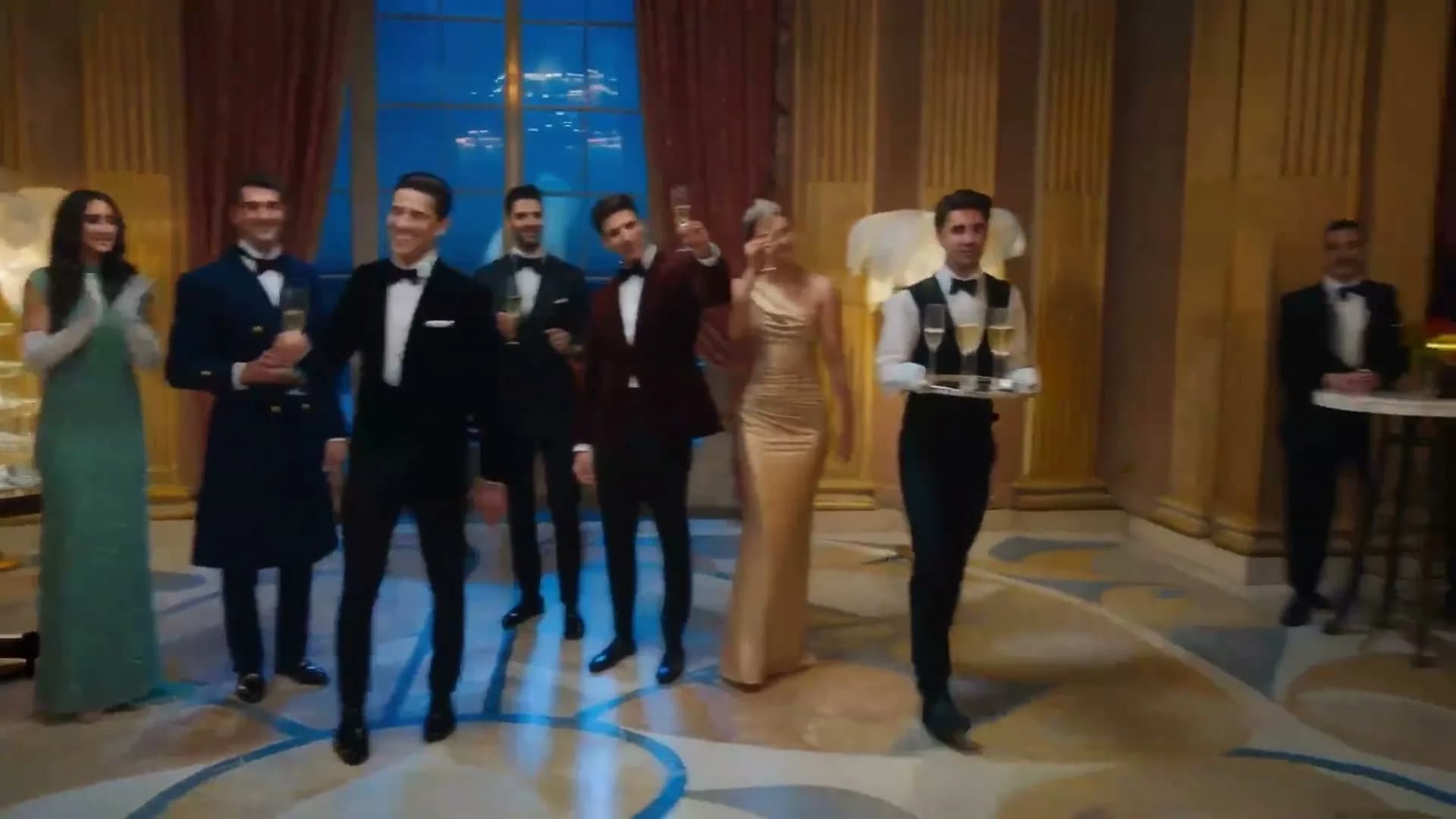 An ensemble cast gathered in an elegant ballroom
